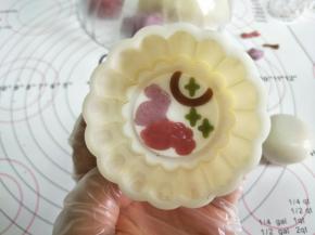 模片放入模具，再四周撒薄薄的熟粉。放入包好馅的面团。