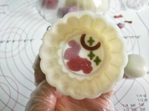 模片放入模具，再四周撒薄薄的熟粉。放入包好馅的面团。