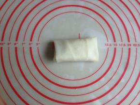 再将有豆沙馅的一端春卷皮向上折