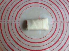 再将有豆沙馅的一端春卷皮向上折