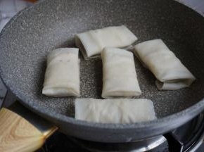 不粘锅里抹上油，烧热。将豆沙春卷放在锅里，用中小火煎
