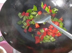 锅内的底油，放入青椒，红椒，翻炒。