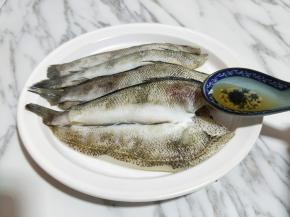 将洗好的冰鱼放入盘子中，加入料酒。