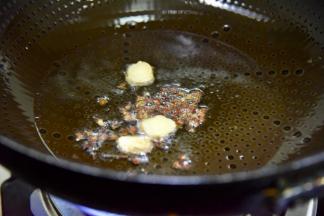 锅烧热，放油，油温6成热时放生姜片、蒜头，花椒，小火熬出香味