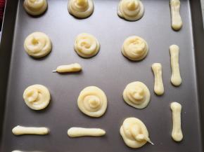 9.	裱花袋前面剪一个大小适中的口，在不粘烤盘上挤上向个圆形的和几个条状的，分别做蘑菇的顶和蘑菇的柄，