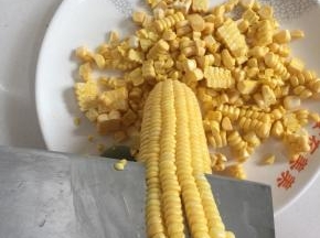 用刀把甜玉米粒削下来，注意不要弄伤了手哦！