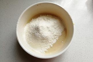 面粉和泡打粉混合过筛到蛋液中，然后再用搅拌刀翻拌至无干粉状态。