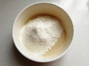 面粉和泡打粉混合过筛到蛋液中，然后再用搅拌刀翻拌至无干粉状态。