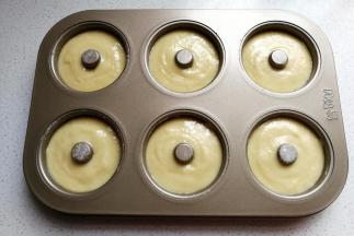 接着把拌好的面糊装入裱花袋中，再挤入到甜甜圈模具中七八分满，然后放入预热好的烤箱中层上下火180度，烤约20分钟左右。