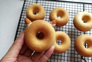 接着把扁桃仁沾点巧克力，插入到甜甜圈合适的部位当作猫咪的耳朵。