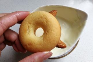 再把甜甜圈放入巧克力中沾上一层巧克力，两只扁桃仁耳朵也要裹上巧克力。（融化的巧克力底部坐一碗热水，这样巧克力不会马上凝固）