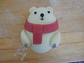 用黑色的面团做熊的眼镜，嘴巴，还有爪子，粘不住的话稍微刷一点点水