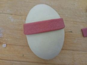 取一块红色面条围在身体的1/3处，多出来的裁掉