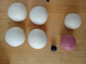 将面团分成4个45克的面团，剩下的面团取两块分别揉入适量的红曲粉和竹炭粉，剩下的一块白面团用来做胳膊和耳朵（红色的不用揉太多，黑色的只需要一点点大就可以了）