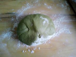 案板上放入面粉，把醒好的面团放上揉匀