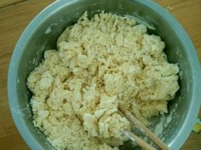 除黄油和紫薯以及紫薯泥用的白糖外的材料混合，慢慢加入温水，用筷子搅成絮状。然后用手揉均匀。
