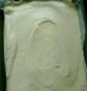 把三分之一蛋白糊放到蛋黄糊里，翻拌均匀后重新倒回蛋白糊里，继续翻拌至顺滑，然后倒入烤盘。