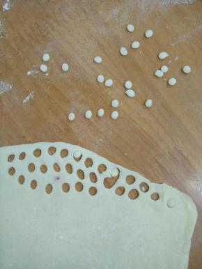 白色面团擀成薄片，压出小圆形。