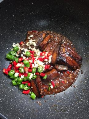 待汤汁儿烧至浓稠，放入切好的小米辣和青尖椒圈，蒜末翻炒均匀。