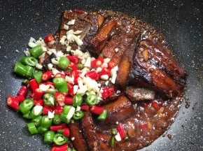 待汤汁儿烧至浓稠，放入切好的小米辣和青尖椒圈，蒜末翻炒均匀。