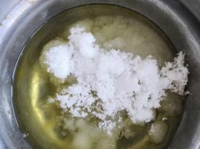 再把糖倒入，用手动打蛋器搅拌糖溶化