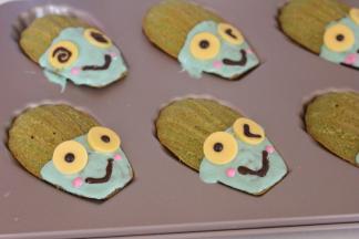 绿色巧克力挤入玛德琳上，带稍微凝固放上眼睛，黑色巧克力画嘴巴，粉色巧克力画表情，然后放入冰箱冷藏10分钟即可