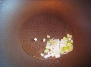 不粘锅里倒入适量的食用油，倒入葱翻炒煸香。