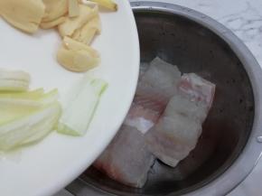 洗干净的鱼块放入盆中，再加入葱姜蒜