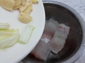 洗干净的鱼块放入盆中，再加入葱姜蒜