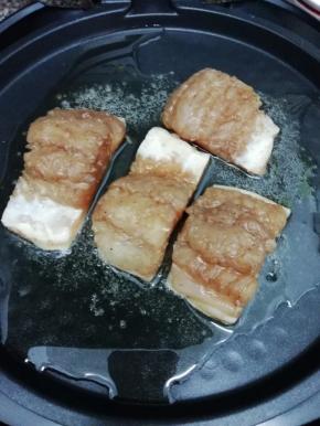 腌制好的鱼块取出，电饼铛中加入适量的油，然后将鱼块放入