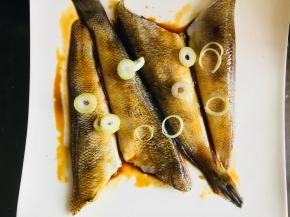 然后将耗油也涂抹在鱼身上。放上葱，适量橄榄油腌制30分钟。可以覆盖上保险膜。放到冰箱里冷藏腌制。