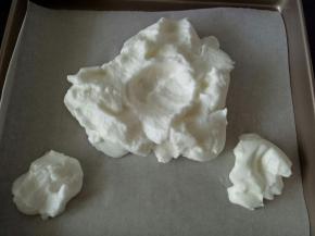 将蛋白霜放到烤盘上，整成云朵的形状，中间留一个小坑