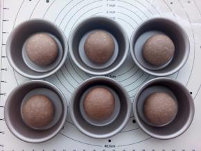 每份大面团用手再欢揉成圆形（相当于排气，但是不要太用力）放入阳晨汉堡模具里，进行二发，二发温度不要超过38度。耳朵部分不用动继续盖上保鲜膜放置。