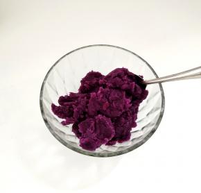 紫薯去皮切片，将其蒸熟，趁热搅拌成泥，再加入少许的纯牛奶调节它的软硬度。