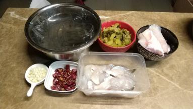 鱼肉切片放入一个蛋清、油、盐拌匀腌制一会儿，鱼头另装起；酸菜切丝；辣子切粒；蒜剁碎；粉条泡软