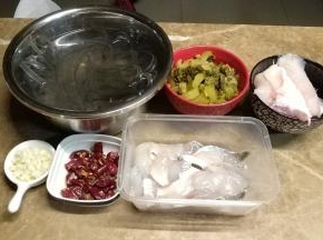 鱼肉切片放入一个蛋清、油、盐拌匀腌制一会儿，鱼头另装起；酸菜切丝；辣子切粒；蒜剁碎；粉条泡软