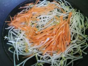 锅里放水烧开，然后倒入绿豆芽和胡萝卜丝，过水焯一下