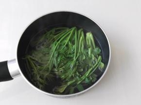 锅里倒入水烧开，然后把香椿放进去焯烫一分钟，叶子变绿就可以了，香椿为什么要焯水呢，因为香椿里含有亚硝酸盐，经过焯烫亚硝酸盐含量大大降低，对身体的伤害也降到最低了。还有一个方法可以一年四季吃到香椿芽，就是焯烫之后晾凉把水分挤一下，然后装进保鲜袋放入冰箱冷冻，便随时可以吃了，拿出来解冻洗一下即可食用。