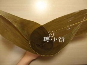 干粽叶用清水泡软，刷洗干净后煮5-10分钟，剪去硬梗部分。
取两片处理好的粽叶，互相交叠卷成漏洞形（如图）。