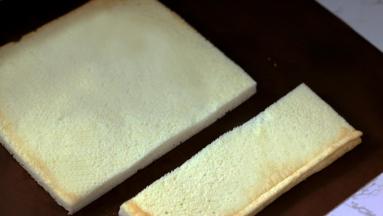 【最后组装】

20.将烤好的蛋糕卷根据模具尺寸进行切割（这款蛋糕由于卡士达酱质地非常软，所以需要模具来辅助定型）