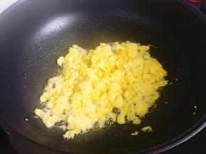 锅里倒入少许油，烧热后倒入鸡蛋液煎香并捣碎，盛入碗里备用。