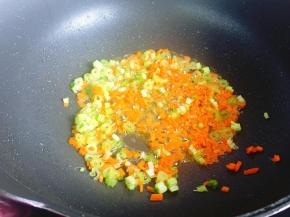 锅里留少许油，放入西芹丁和胡萝卜丁炒至八九分熟。