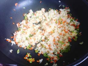然后将提前弄散的米饭倒入锅里，翻炒均匀并炒散。