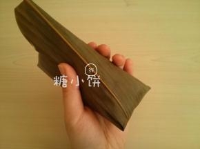 把余出来的叶片部分顺着三角形的那个表面翻折过去，再沿着侧边包裹下去就形成了一个四面都是长等腰三角形的龙舟形。
再多余的叶片部分（如图左上）沿着边翻折下来，用棉绳捆好