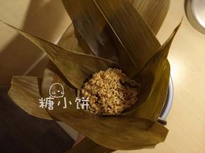 表面再铺上米料，覆盖住所有馅料。左右两边各加一片叶子（如图）