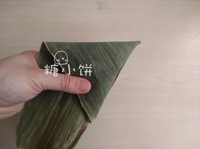 再继续沿着边，绕着包，包至不足以再继续绕为止。
重点在于包的时候角一定要裹严实，否则容易漏米。
我是裹第一圈的时候每一个尖角位置折一个折角，再往后绕就不用折了。