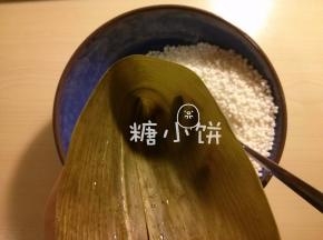 干粽叶提前用清水泡软，剪去硬的那部分叶梗，卷成一个锥形筒