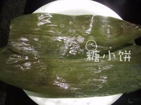 干粽叶提前用清水泡软，洗刷干净，剪掉硬的那部分叶梗。开水煮3-5分钟备用。
取两张粽叶横着交叠在一起加宽（如图示）。