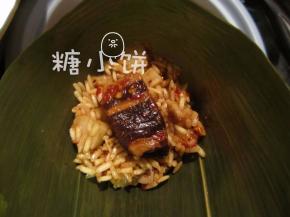 干粽叶提前用清水泡软，洗刷干净，剪掉硬的那部分叶梗。
卷成一个锥形筒，填部分米料，摆上腌好的五花肉块。