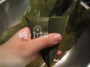 剩余粽叶翻折过来包好，用棉绳捆紧